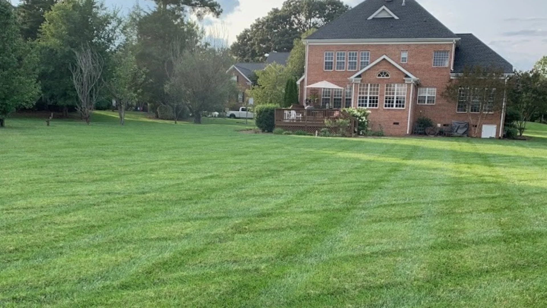 Residential home in Dallas, TX with a healthy green lawn from fertilization services.