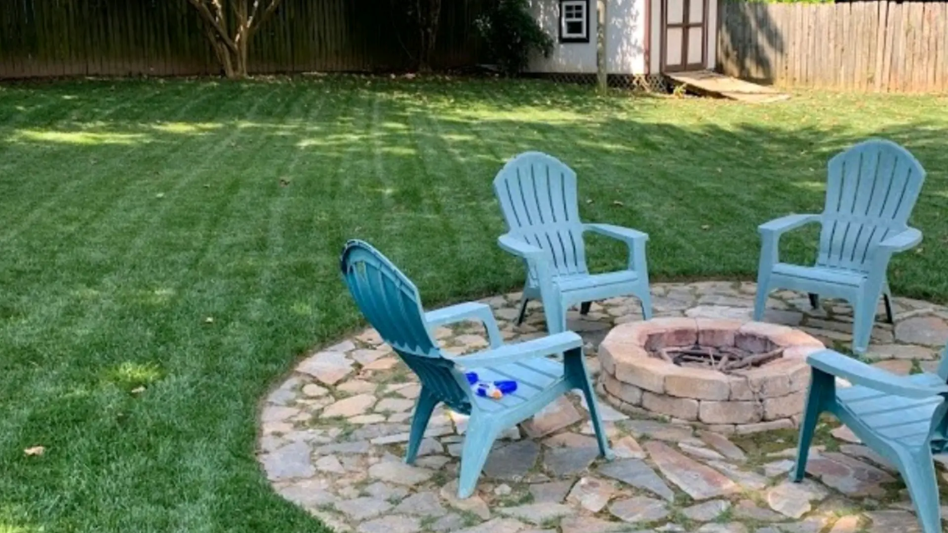 Large backyard in Dallas, TX with patio, fire pit, and lush green lawn.