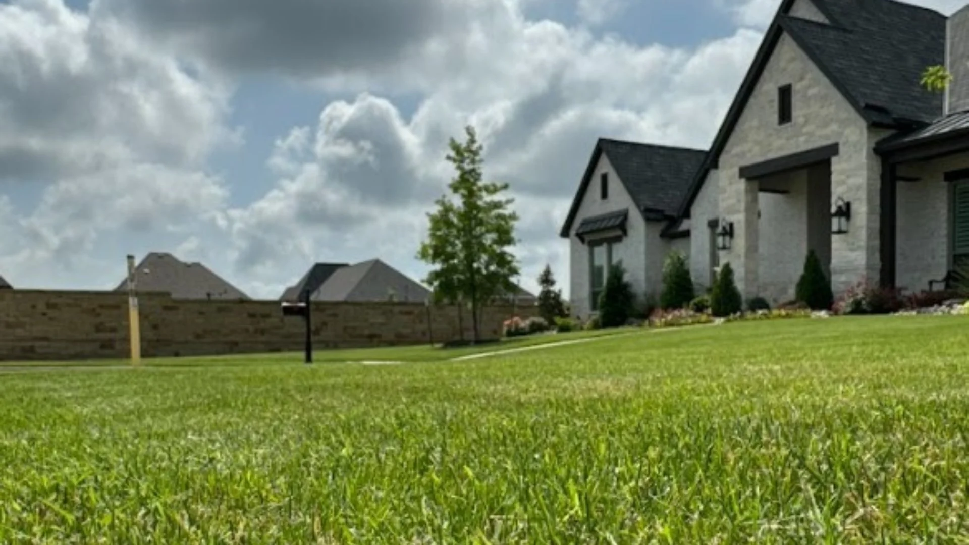 Lawn in front of home with clouds in background in Granbury, TX.