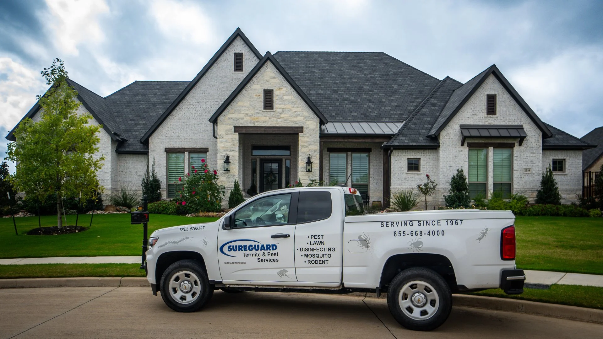 Truck parked in front of a residential house with a well-maintained lawn and garden plants in Crowley, TX.