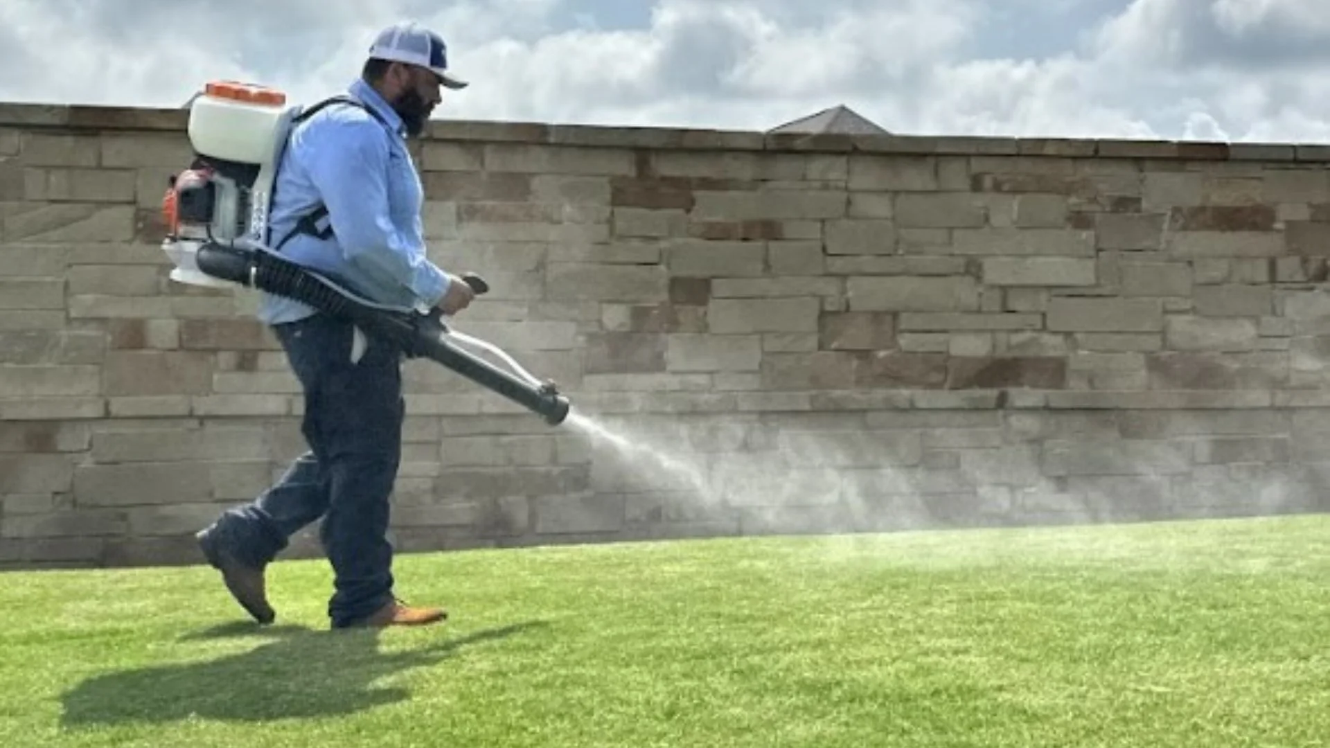 Worker applying fogger treatment to lawn in Godley, TX.