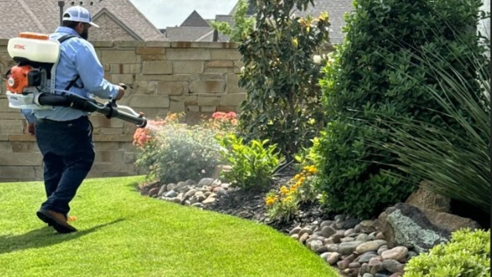 Worker applying treatment to landscape bed in Garrett, TX.