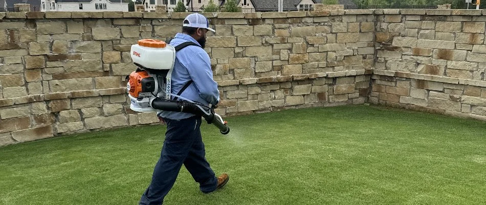 Crew applying mosquito control treatment through a backpack fogger on a lawn in Rowlett, TX.