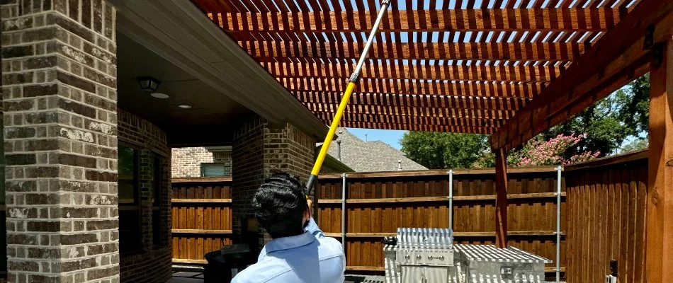 Crew dusting a pergola in Dallas, TX, for a pest control service.