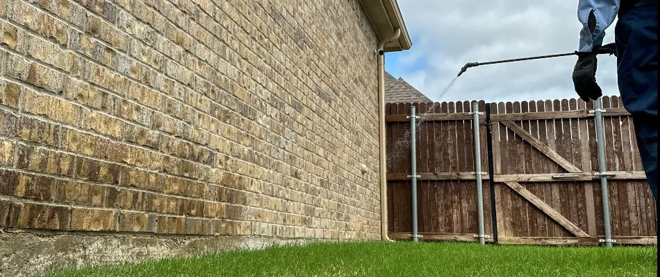 Perimeter pest control treatment being applied to a home foundation in Fort Worth, TX.