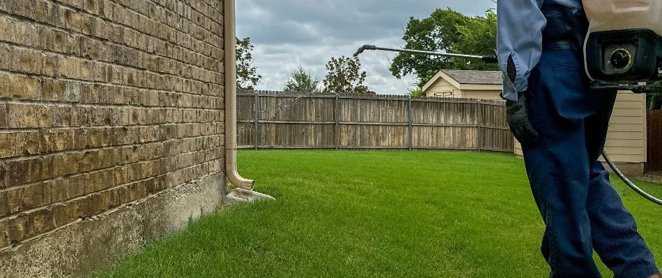 Perimeter pest control treatments being applied on a wall in Dallas, TX.