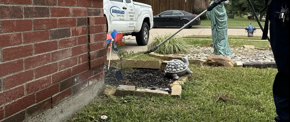 A pest treatment being sprayed to a brick wall in Burleson, TX.