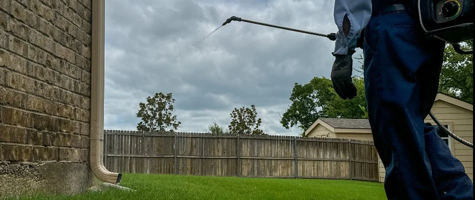 Professional in Mabank, TX, applying perimeter pest control treatment on a property in Mabank, TX.