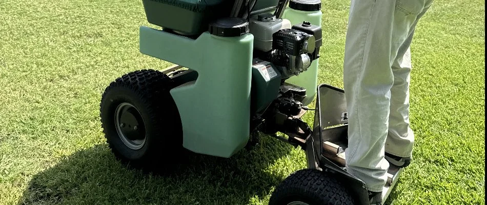 A worker in Burleson, TX, on a ride-on lawn spreader.