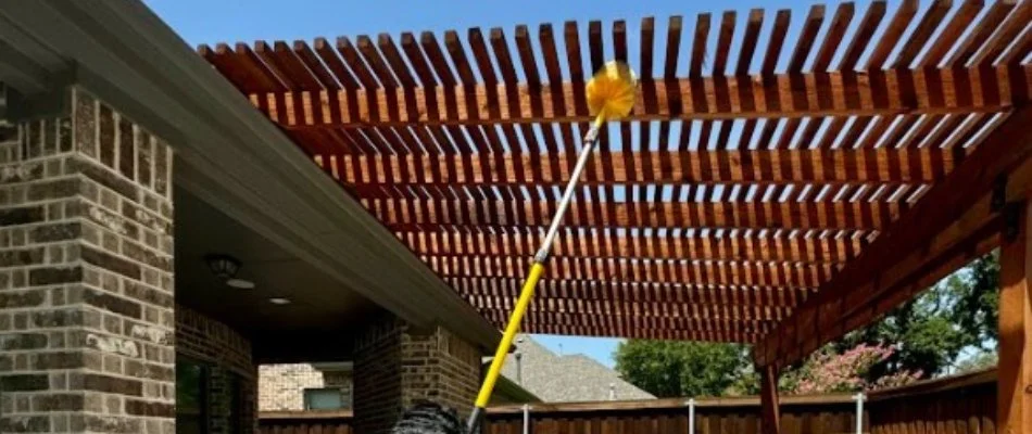 Pole sweeping pergola for spider webs in Garrett, TX.